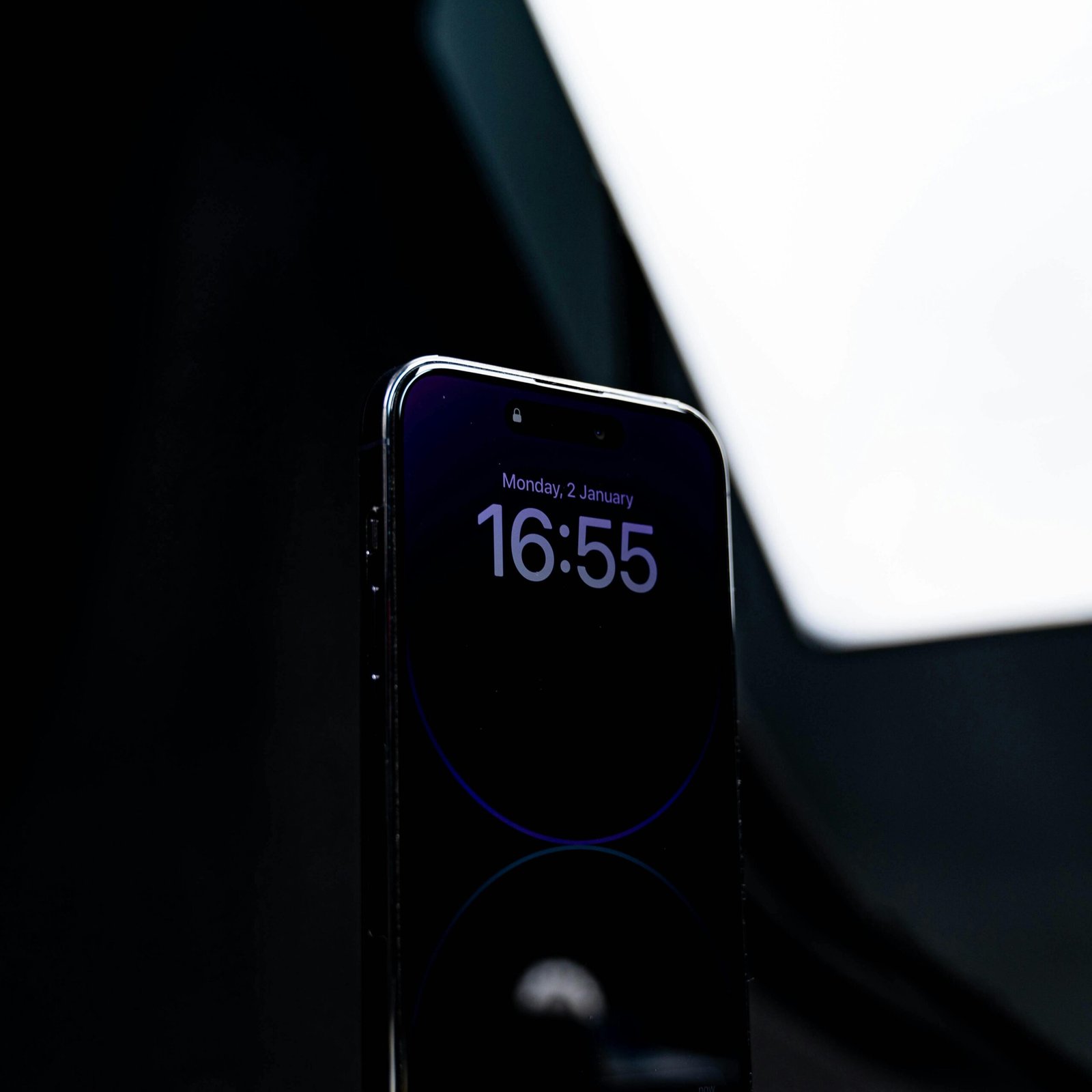 Close-up of a smartphone displaying time against a dark backdrop, highlighting screen technology.